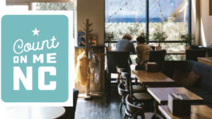 Count On Me NC program logo beside a photo of a cafe with two people sitting at a table by the window